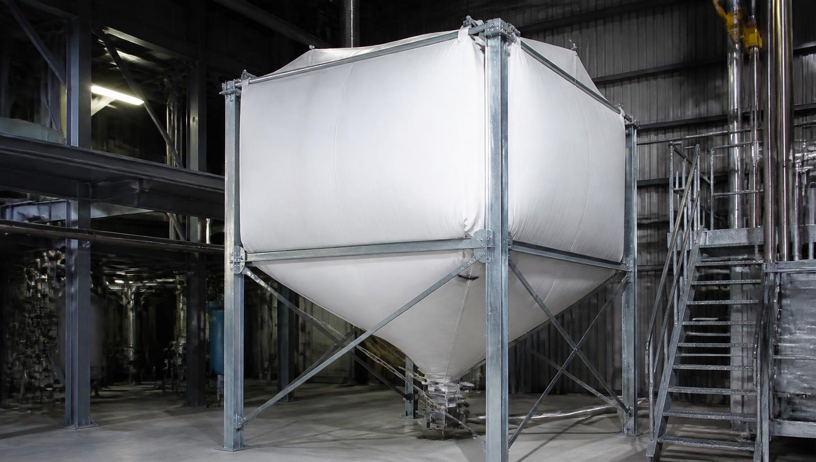 Flexible fabric silo on steel support frame used for bulk material storage in an industrial plant