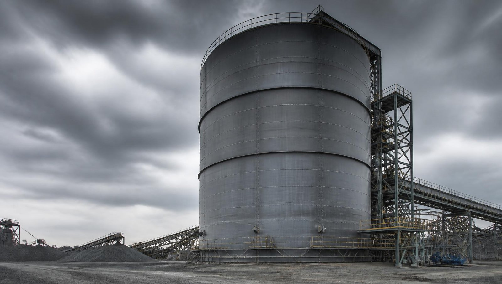 Large welded industrial steel storage silo at a bulk material processing plant